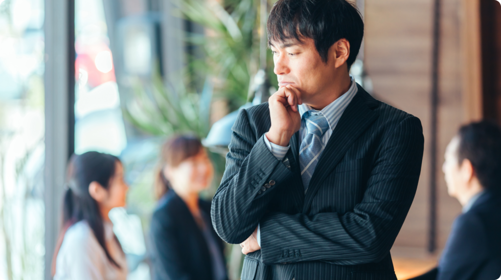 悩んでいるスーツ姿の男性の写真