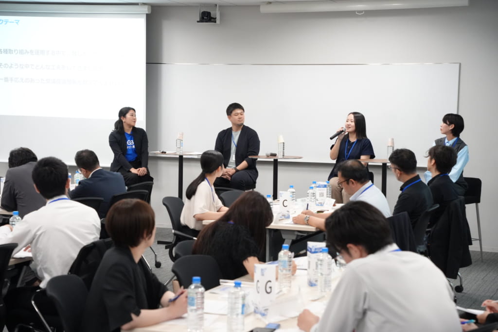 前方ステージに登壇したパネリストと聴講する参加者