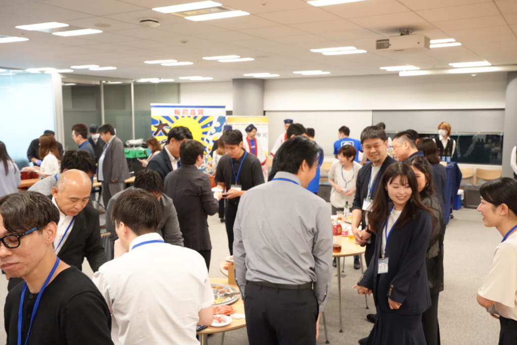 立食形式で笑顔で交流や歓談を楽しむ多くの参加者の様子